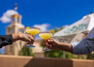 Two people toasting with salty margaritas outdoors, highlighting the leisure available at Napa Valley hotels.