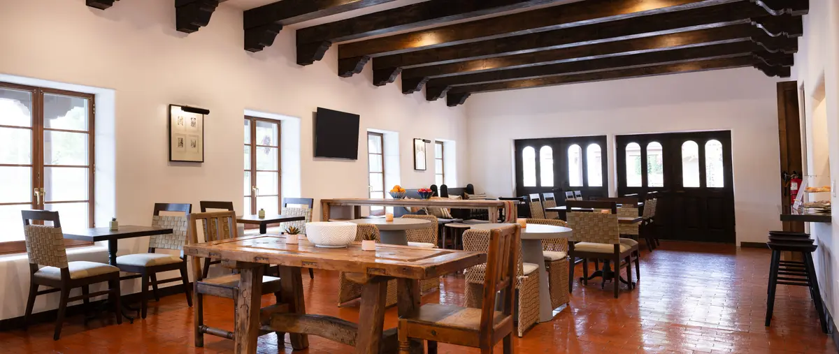 Rustic hotel breakfast room in Napa CA at Piñon Court featuring dark wood beams and varied seating.