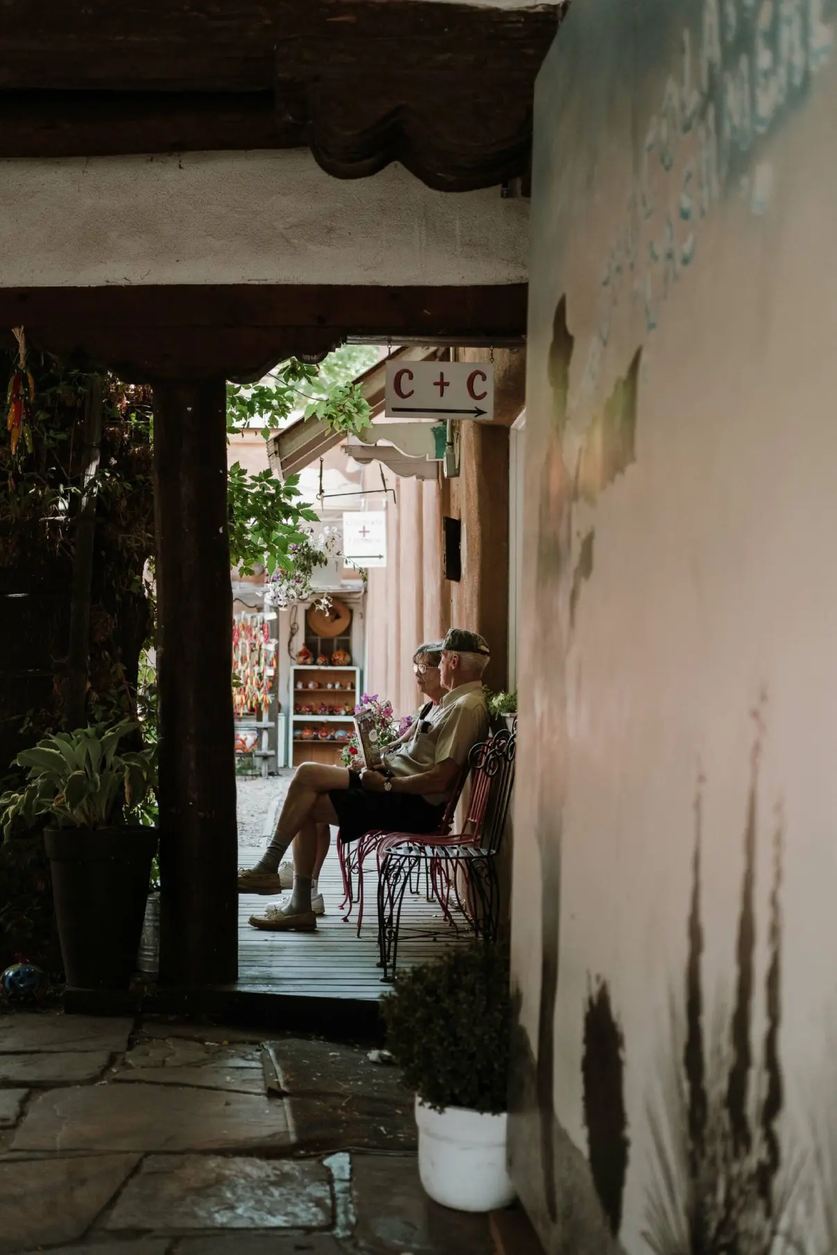 Couple seated on wrought iron chairs in a shaded rustic entryway, reflecting the relaxing atmosphere of Napa Valley hotels.
