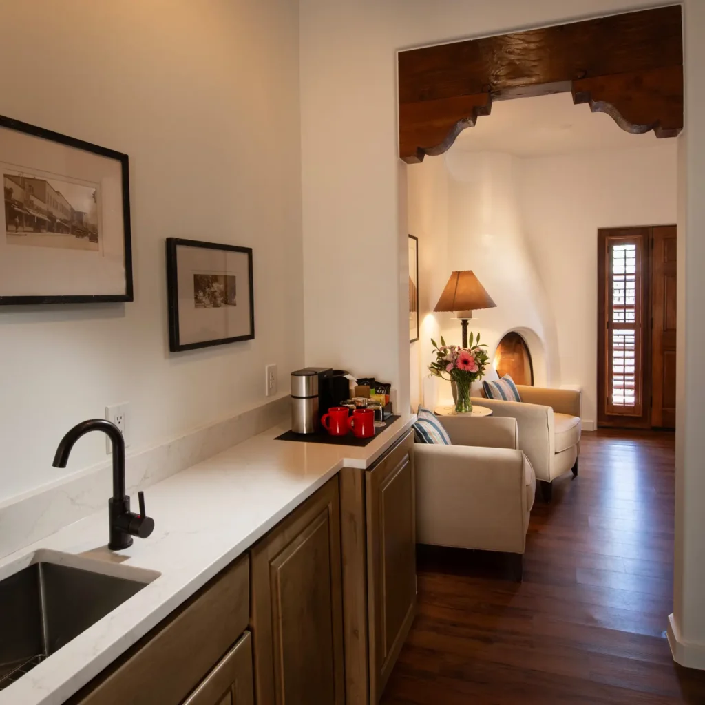 Comfortable hotel sitting area with fireplace and a kitchenette counter with a coffee maker, typical of hotels in napa ca.