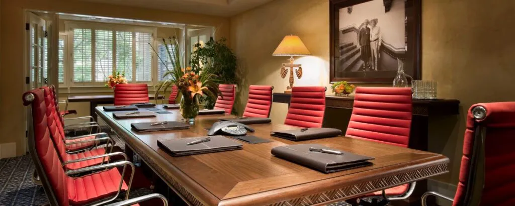 Luxurious conference room with a long wooden table and red chairs, suitable for napa valley event venues.