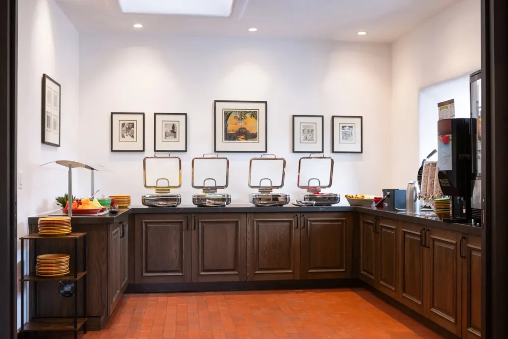 Modern breakfast buffet setup featuring chafing dishes, fresh fruit, and dark wood cabinetry at a napa ca hotel.