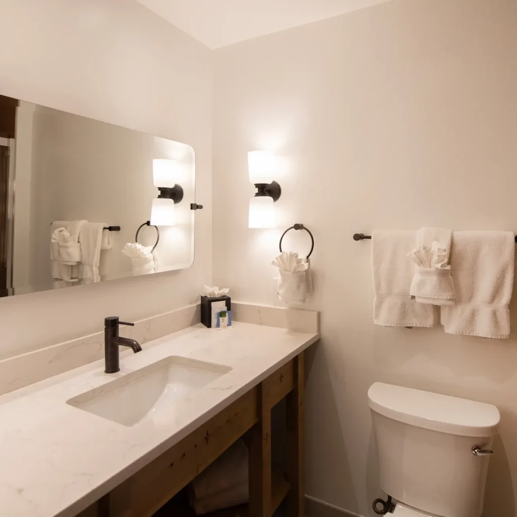 Upscale hotel bathroom featuring a marble vanity, modern black fixtures, and fresh towels at a napa valley hotel.