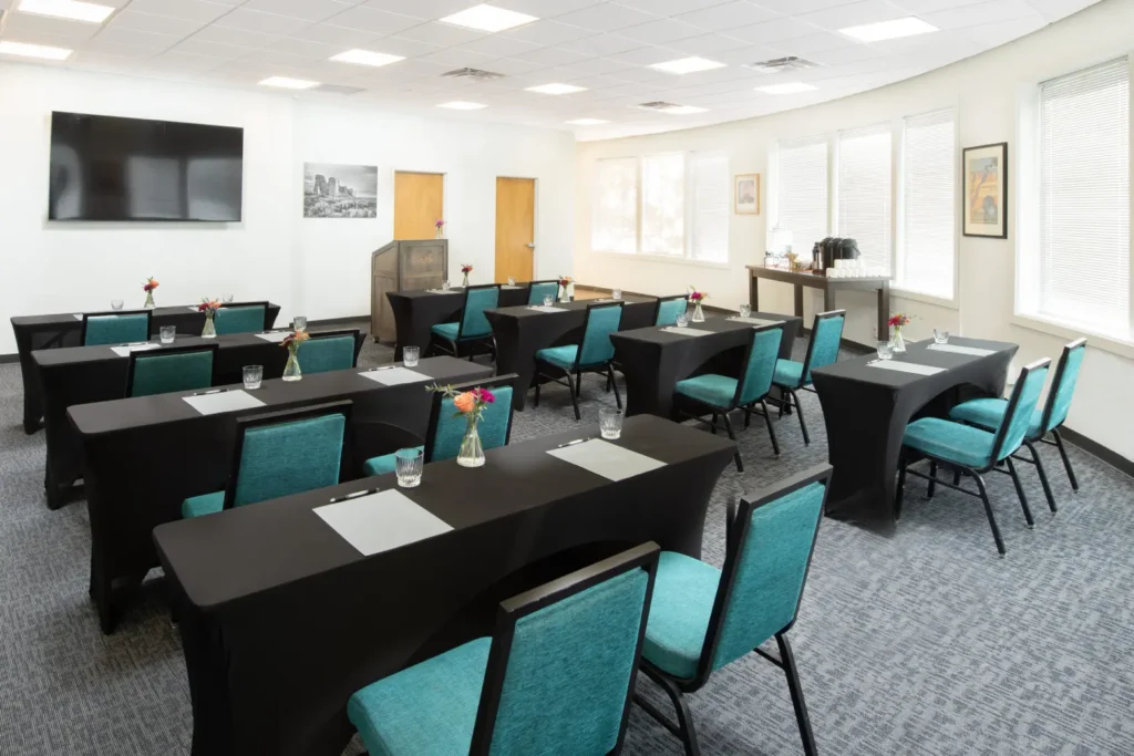 Classroom-style meeting room with teal chairs and black tables, available for napa valley event venues.