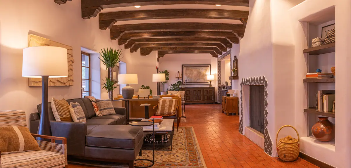 Elegant Piñon Court hotel lobby with dark wood beams, leather seating, and tiled floors, a welcoming Napa Valley hotel interior.