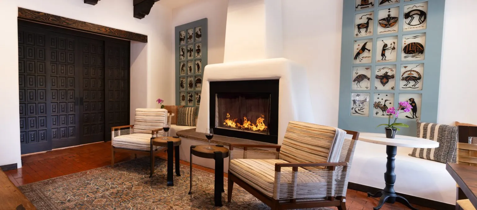 Luxurious seating area with a Southwestern fireplace and unique artwork inside a Napa Valley hotel and suites.