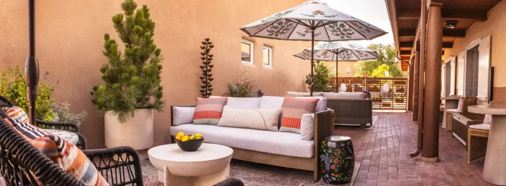 Inviting outdoor hotel patio with comfortable seating, decorative umbrellas, and planters at Napa Valley hotels.