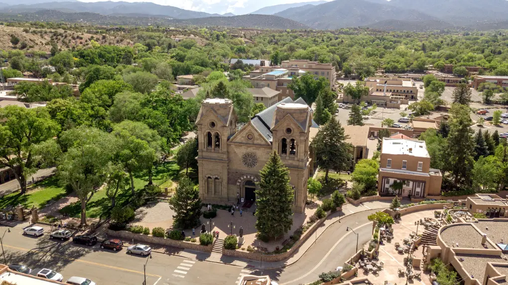 An aerial view of a church and surrounding buildings in a mountainous area.