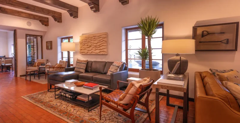 Cozy, rustic-chic living room with a dark sectional and wood beams, typical of napa valley hotel and suites.