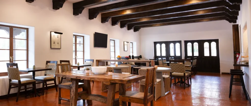 Rustic, Spanish-style hotel dining room for breakfast places in Napa CA, featuring dark wood beams and tile floors.